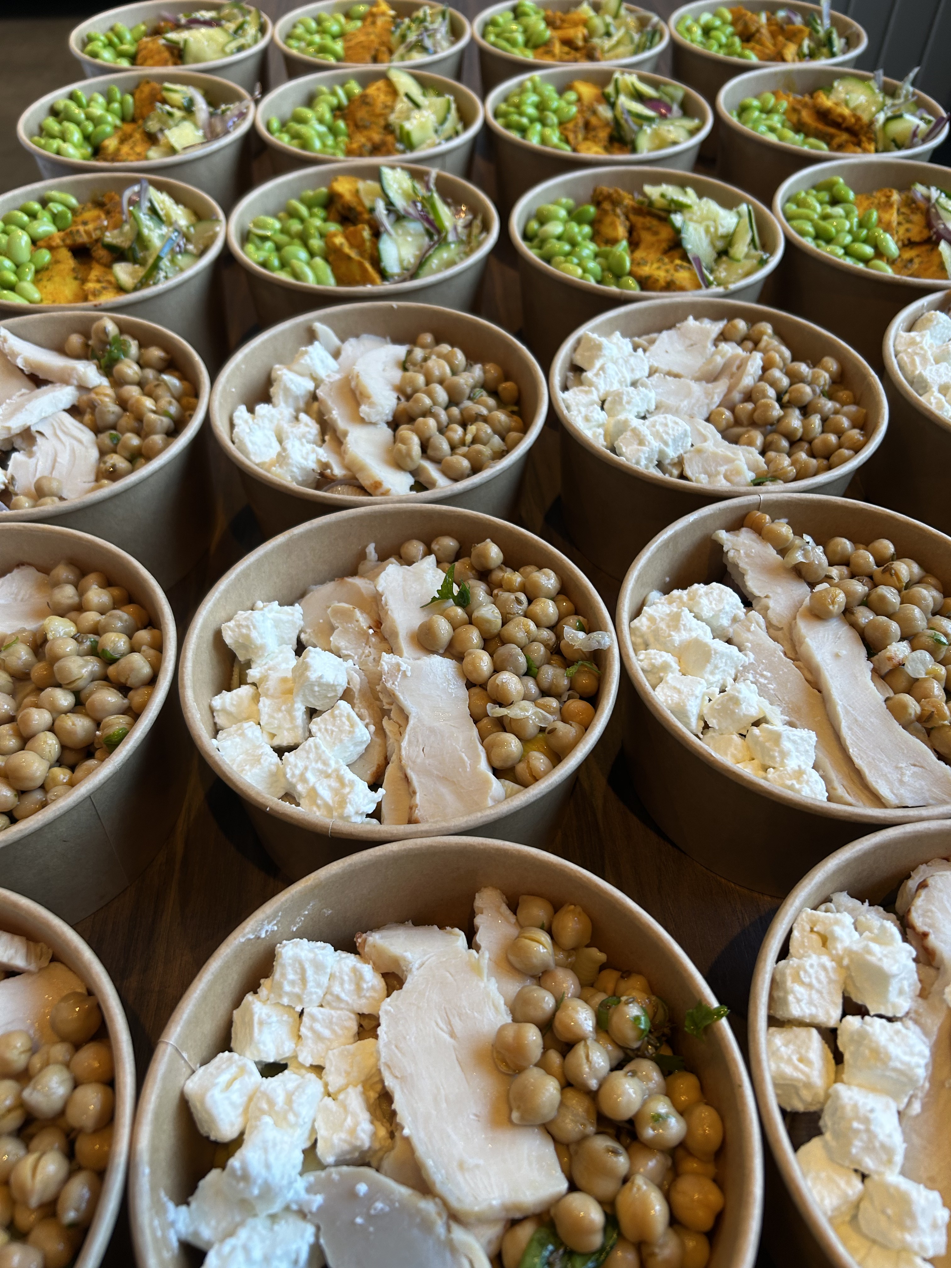 Bols de plateaux repas préparés en nombre chez Les Petites Natures : poulet, pois chiches et préparations du jour